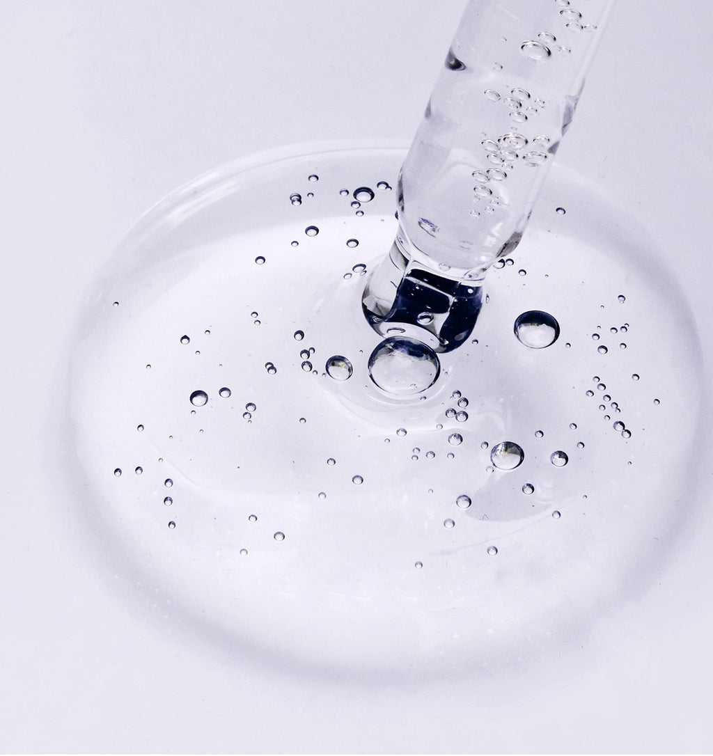 Skincare ampoule with white and black graphic design on a white background