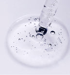 Skincare ampoule with white and black graphic design on a white background