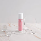 Skincare bottle with pink label on a marble surface