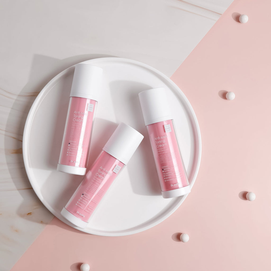 Three pink lip balms with white caps on a white plate against a pink and beige background.
