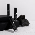 Three black Dr. Esthe retinol skincare bottles with labels on a light gray background