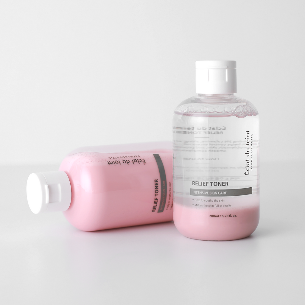 Two bottles of Eclat du teint Relief Toner skincare products on a light gray background