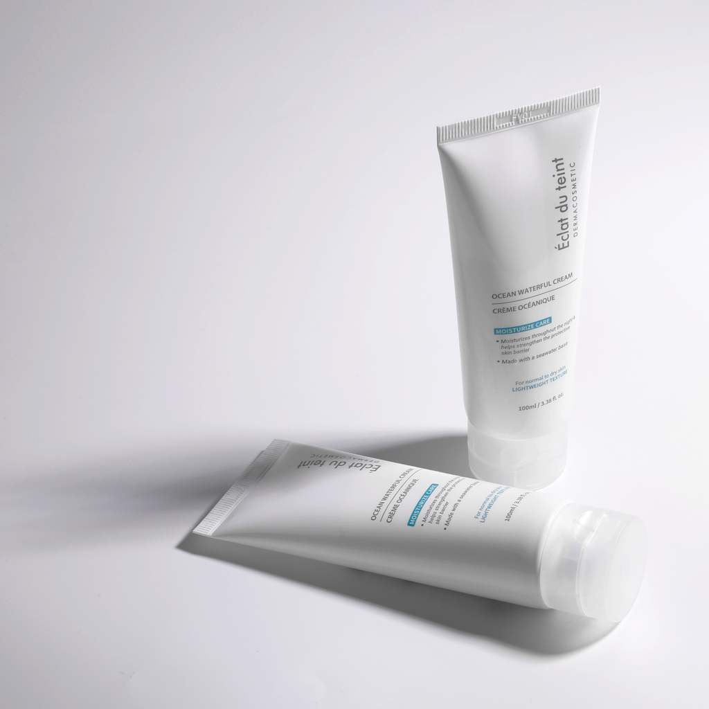 Two tubes of facial moisturizers Eclat du teint Ocean Waterful Cream on a light gray background